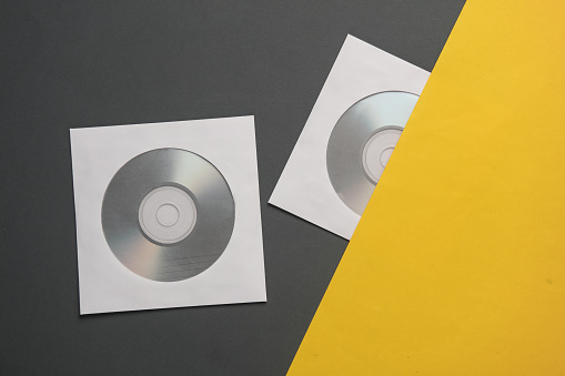 Mockup of CD discs in Paper packs on yellow gray background