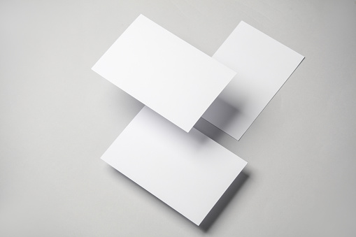 Floating blank white cards on gray background with shadow. Minimalism, modern business still life, creative layout