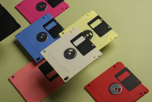 istock Floating colored retro 80s floppy disks on a green background. Conceptual pop, creative layout 2042051586