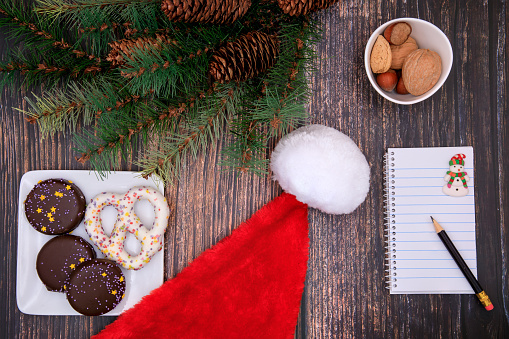 Christmas background with gingerbread, notebook and santa claus hat