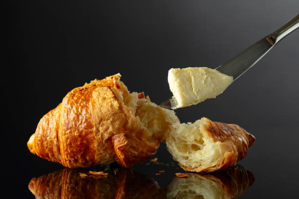 istock Fresh baked croissant with butter on a black background. 2042084461