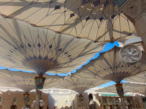 A view of being under the giant convertible sunshades of Medina Haram Piazza at midday.