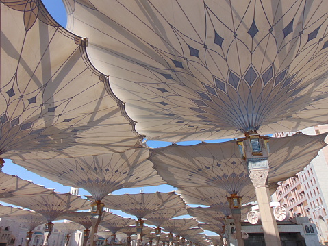 A wide view of the opened umbrellas of the Prophet's Mosque at noon.