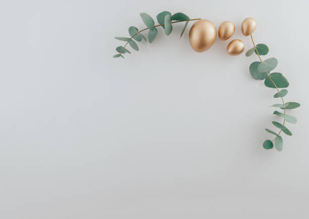 istock Golden eggs with green eucalyptus leaves. Easter decoration pastel white background. Top view square 2042152709