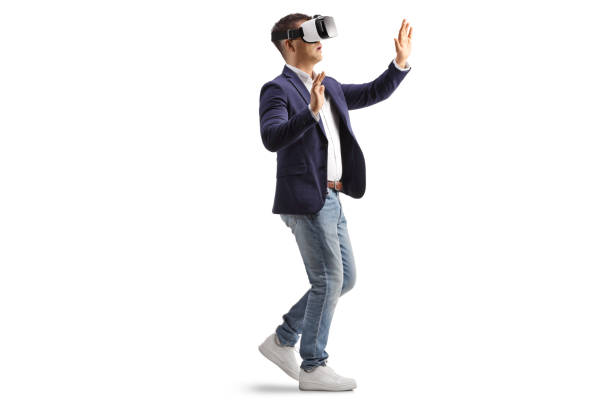 istock Businessman with a VR headset walking and touching with hands 2042188410