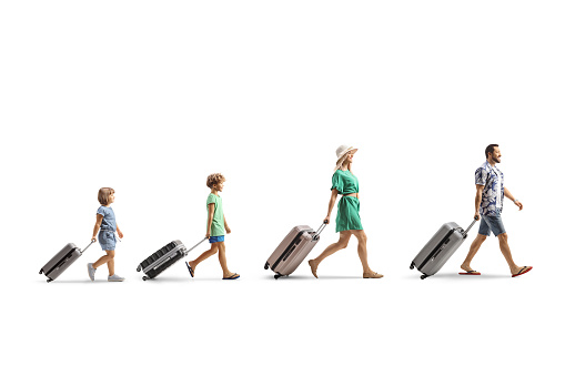 Family with children walking and pulling suitcases isolated on white background