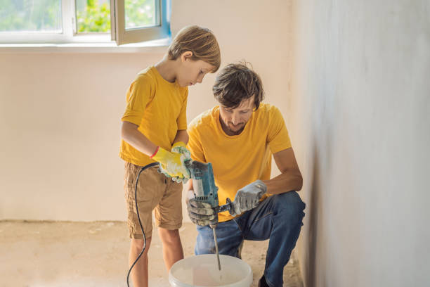 man with his son makes repairs at home, he teaches children to plaster the walls with a spatula in his hands - plaster plasterer work tool child imagens e fotografias de stock