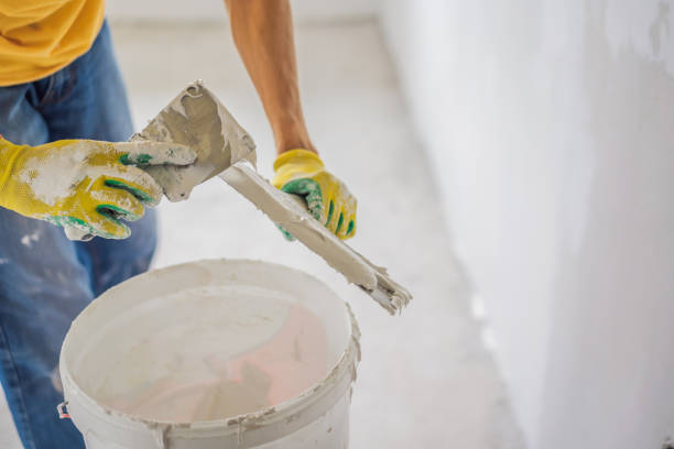 istock Plasterer home improvement handyman worker with putty knife working on apartment wall filling 2042210200