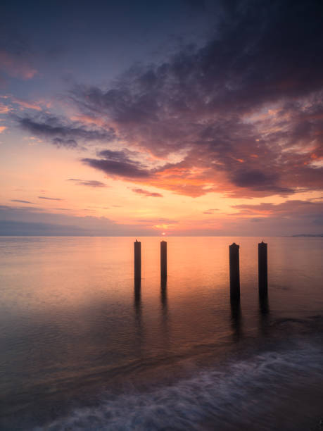 Tranquil Sunset at a Serene Swedish Sea Beach With Wooden Posts