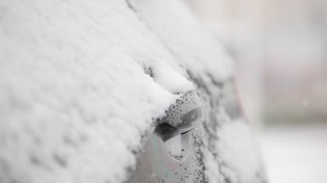 Car door knob under snow in winter