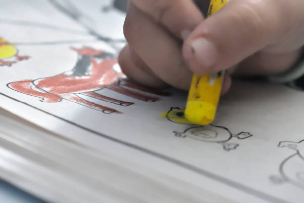 istock Hand holding a wax crayon on a paper. 2042219196