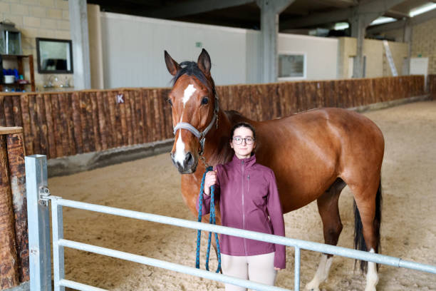 istock Young Equestrian Posing with a Bay Horse at Stable 2042234469