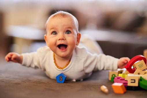 Happy baby girl enjoying while playing with wooden toys.