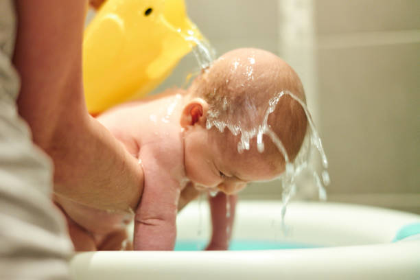 Close up of wet newborn baby girl in mother's hands.