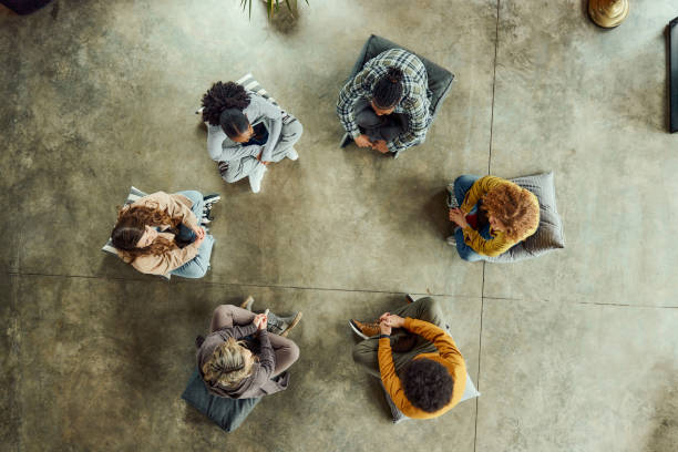 istock Above view of young people having a group therapy in a circle. 2042276225