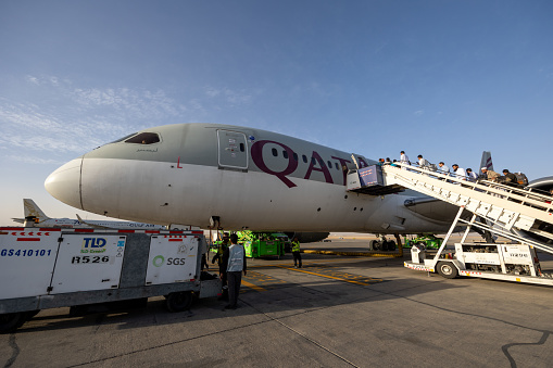 Riyadh, Saudi Arabia - February 25, 2024 : Passengers board a Boeing 787 Dreamliner aircraft, operated by Qatar Airways at King Khalid International Airport in Riyadh, Saudi Arabia.