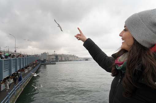 Young woman walking on the Galata Bridge in Istanbul, Turkey.