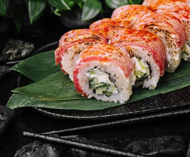 Photo of Philadelphia sushi rolls with filling of cream cheese, cucumbers with fresh tuna fillet