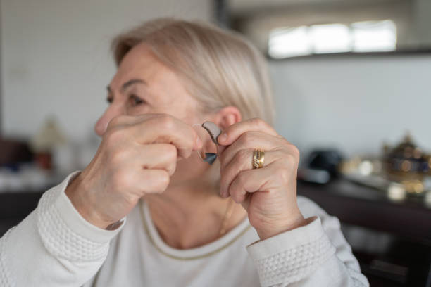 istock Old Woman Holding A Hearing Aid 2042356328