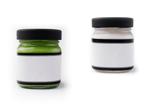 Pesto sauce and cream sauce in a glasses jars isolated