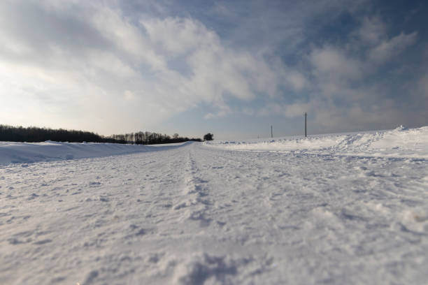 winter road after snowfall in sunny weather, the highway in the snow is illuminated by sunlight