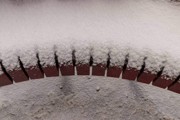 a snow-covered part of a park bench, a bench made of planks in the snow after a snowfall