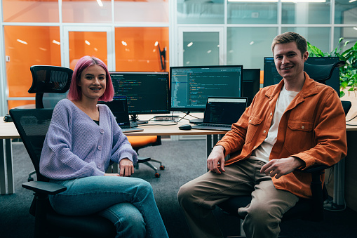 Cinematic image of a programming office with young programmers and software engineer working on a new project for a start up business.