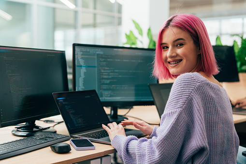 Cinematic image of a programming office with young programmers and software engineer working on a new project for a start up business.