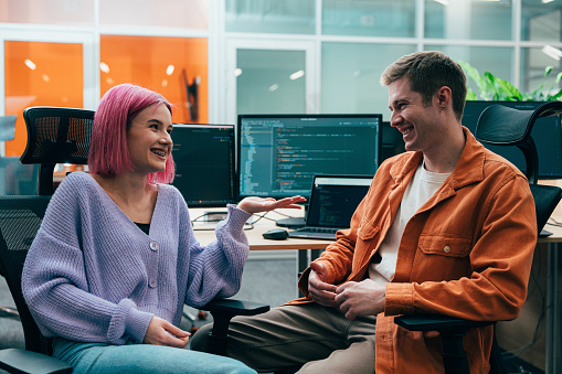 Cinematic image of a programming office with young programmers and software engineer working on a new project for a start up business.