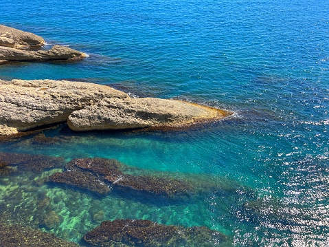 Rocky coast of Mediterranean sea blue turquoise glittering water beautiful seascape.