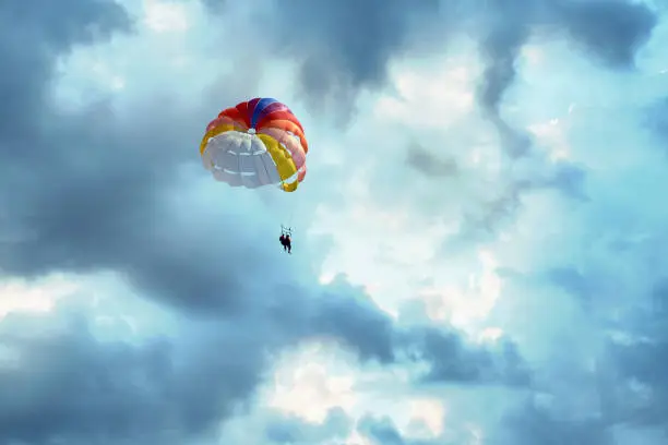 Photo of Couple is parasailing in the blue sky. Summer vacation on the Black Sea.