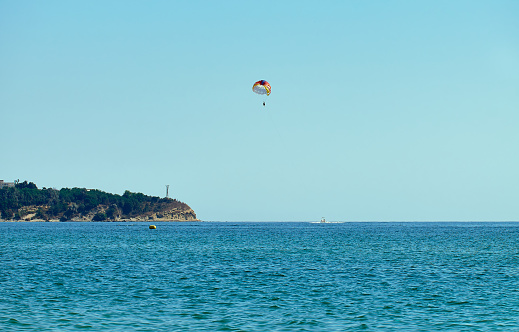 Couple is parasailing in the blue sky. Summer vacation on the Black Sea.