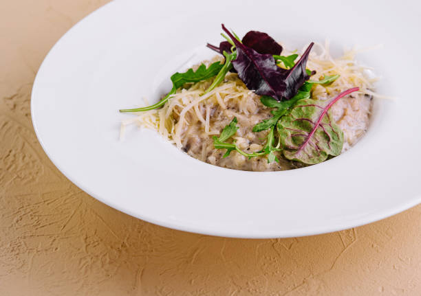 Closeup of beautifully served pasta with chicken meat and arugula.\nShot with Canon R5