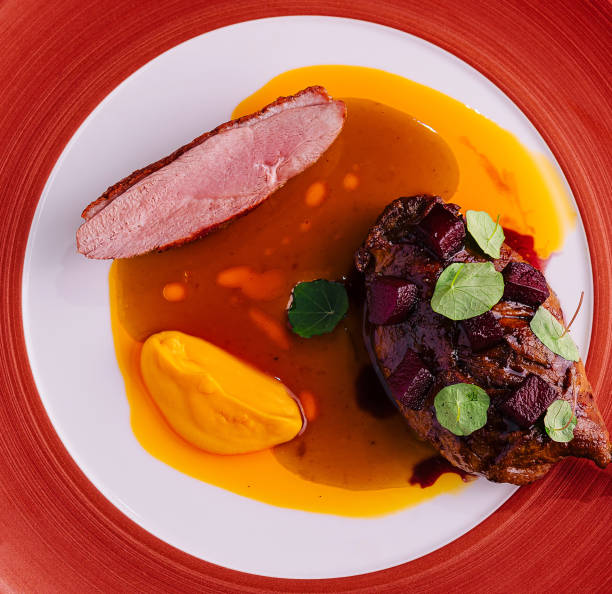 istock duck leg with pumpkin puree on red plate 2042409066