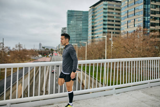 istock Sportsman standing on overpass and stretching quadriceps 2042417570