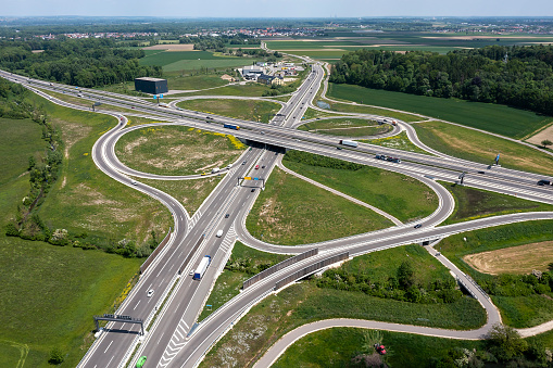 Highways and highway interchange with car and truck traffic seen from above in spring.
