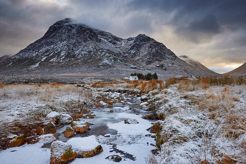 River Coupall frozen Glencoe with Lagangarbh cottage and Buachaille Etive Mor in the background Scottish Highlands Scotland UK. The sun has almost set