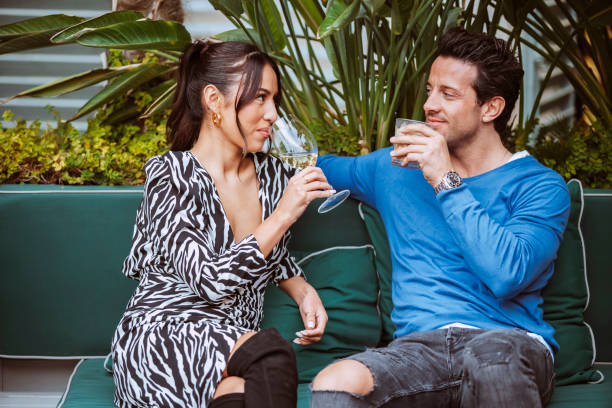 istock Multiethnic smiling couple sits on couch at terrace bar 2042485670