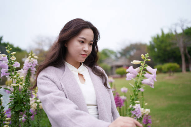 woman admiring flowers in park