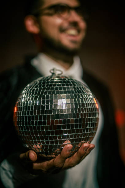 istock Charming young man in a costume playing with a disco ball 2042501415
