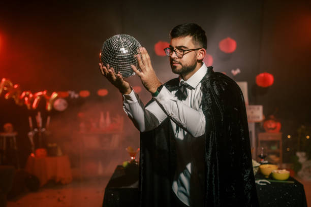 Red background and blue plasma energy beams in glass sphere with hand and fingers touching creating a storm of mini lightning bolts and interesting light patterns.