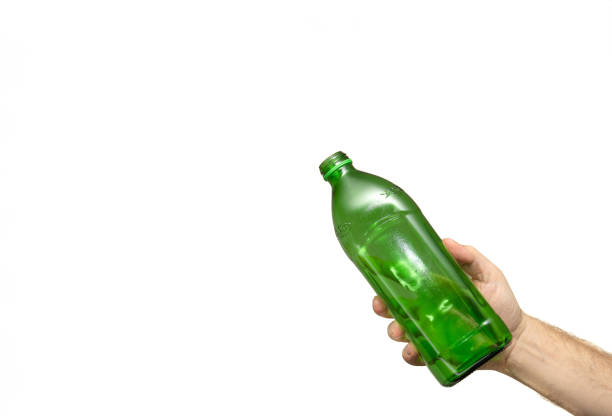 Shattered bottle with sharp edges backlit on ols wooden fence post.