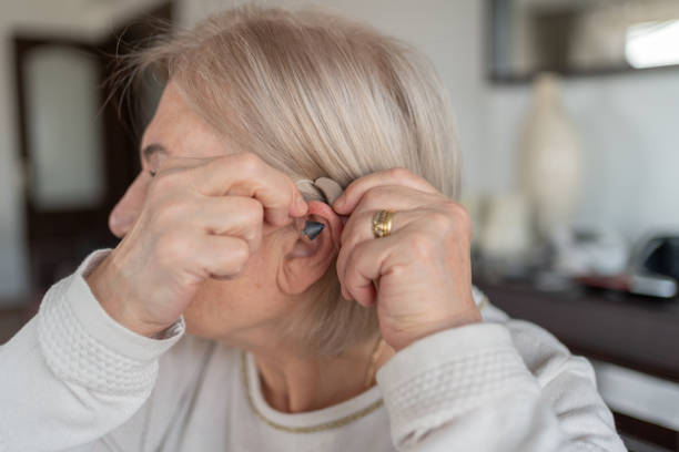 istock Old Woman Holding A Hearing Aid 2042504185