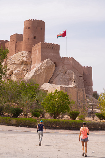Two women walking on sunny day  to the Nakhal Fort, in Oman . Is one of the oldest and biggest forts in Oman, inscribed on the UNESCO World Heritage List