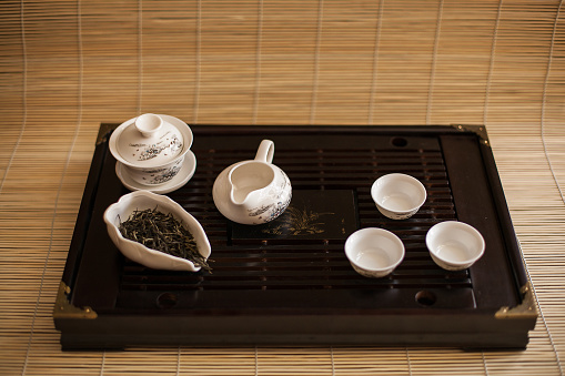 A wooden tray holding a tea set, perfect for serving tea and snacks. A beautiful addition to any kitchen decor, enhancing the dining experience