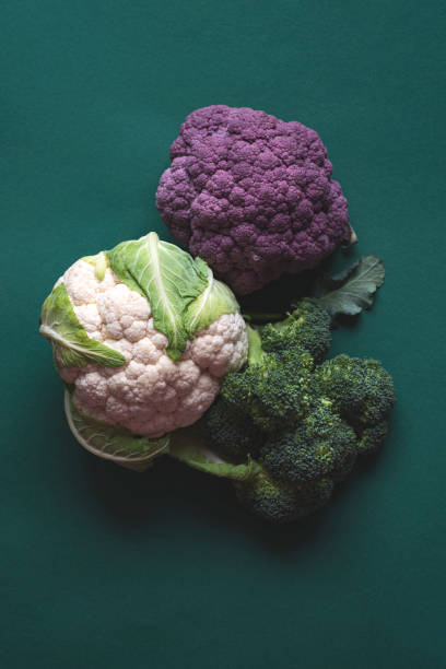 istock Cruciferous cabbages: broccoli, cauliflower and purple cabbage on a green emerald background. Vegetables full of vitamins and minerals, healthy food, farm products, top view 2042537672