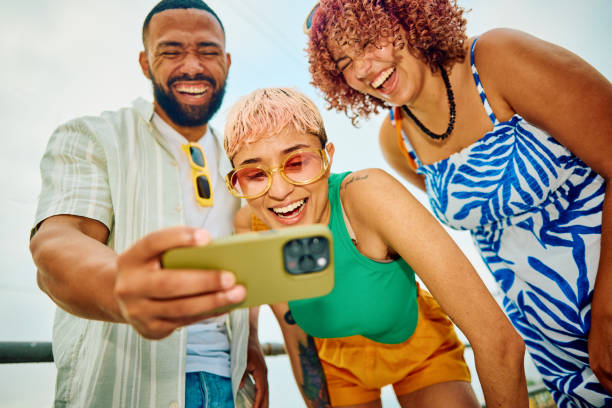 istock Happy group of friends using their smartphone while travelling. 2042539317