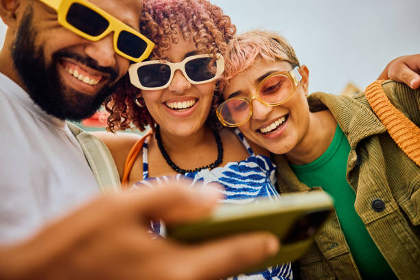 Happy group of friends using their smartphone while travelling.
