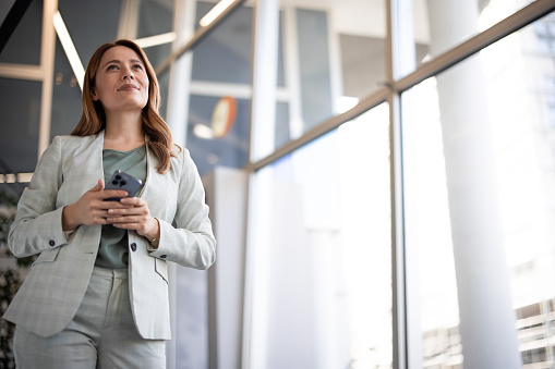 Smiling businesswoman standing in the corridor