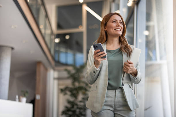 istock Smiling businesswoman using phone in office 2042564951
